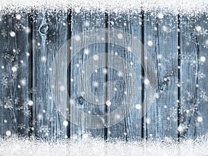 Christmas winter background with snowflakes on blue wood texture with snow