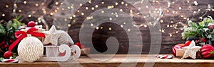 Christmas winter banner with bokeh lights. White sleigh, shiny star, red bauble, gift boxes, fir branches and candy cane. Copy