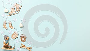 Christmas winter composition with wooden decorations and a toy cat on a blue background. Flat lay top view copy space frame border