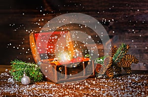 Christmas winter fairy with fantasy miracle in opened chest treasure. Background of mystery gift New Year, fir tree and snow.