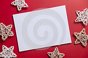 Christmas winter festive ornament. Blank paper card with wooden decoration on red background. Minimal decoration. Invitation