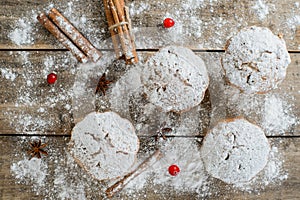 Christmas winter food composition: cakes in icing sugar with cranberry and cinnamon