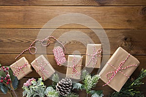 Christmas and winter holidays background. Christmas gift box with pine cones, fir brances, on brown wood table with copy space.