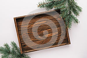 Christmas or winter mock-up scene. old wooden tray and green fir branch on White background. Flat lay, top view. minimalist