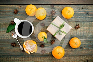 Christmas, winter, new year concept with craft girt box, coffee mug, anise and citrus on wooden background. Flat lay, top view.