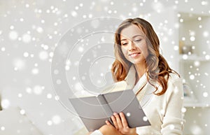Happy young woman reading book at home