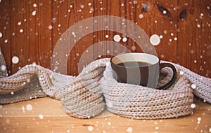 Christmas and winter time. Mug of hot coffee wraped in scarf.