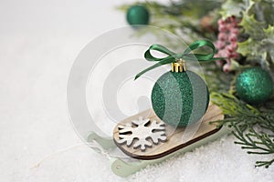 Christmas winter wooden sleigh with green bauble over the snow. Abstract winter greeting card with copy space