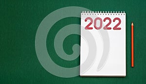 Christmas wishlist 2022 or letter to Santa on green colored paper background. Festive decoration, Christmas garland