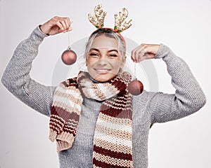 Christmas, woman and baubles with smile in portrait for festive, winter and holiday on studio backdrop. Female person