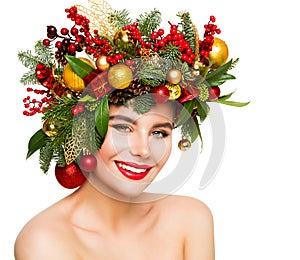 Christmas Woman Beauty Happy smiling. Fashion Model with Fir Tree Wreath Hairstyle decorated with Balls and Gifts. Women Face