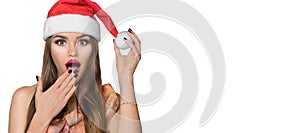 Christmas woman. Beauty surprised model girl in Santa Claus hat. Emotions, joy. Surprised expression. Closeup portrait