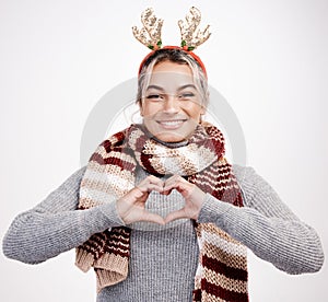 Christmas, woman and heart with smile in portrait for festive, winter and holiday on studio backdrop. Female person