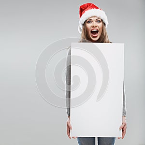 Christmas woman hold big white card. Santa hat.