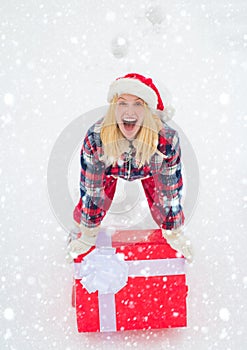 Christmas Woman holding a huge gift box. Girl in snow. Woman present red gift box with ribbon bow isolated over white