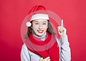 Christmas woman wearing santa hat and pointing up