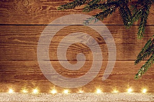 Christmas wooden background. Christmas background with garlands and a branch of a fir tree