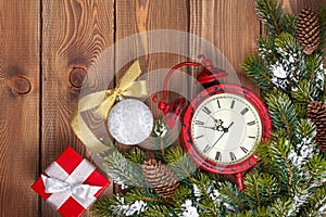 Christmas wooden background with clock, fir tree and gift box