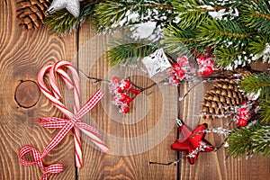 Christmas wooden background with decor, candy canes and snow fir