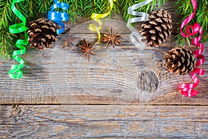 Christmas wooden background with fir branches, cones and serpentine. Top view with copy space