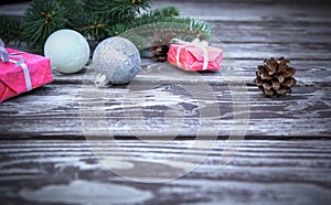 Christmas wooden background with fir tree, gifts boxes, pine cones and christmas balls, view with copy space