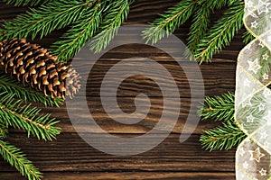 Christmas wooden background with green pine branches and cone