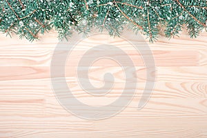 Christmas wooden background with snow fir tree. Light wood background with fir branches. Space for a greeting message. Christmas