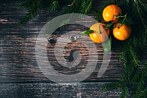 Christmas wooden background with tangerines and fir branches