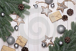 Christmas wooden background with tree branches, pine cones, Christmas balls and gifts