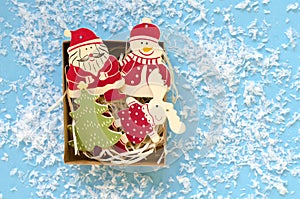 christmas wooden decorative figures in gift box on blue background