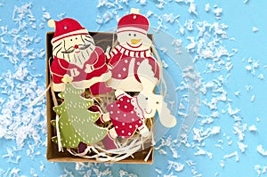 christmas wooden decorative figures in gift box on blue background