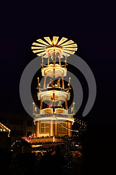 Christmas wooden pyramid rotates with nativity scene, people walking during Christmas market, German Night street Xmas and holiday