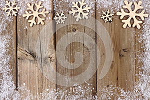 Christmas wooden snowflake top border with snow frame on wood