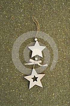 Christmas wooden star shape decoration on green knitted background