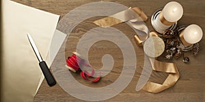 Christmas wooden table with red and golden ribbon and candles