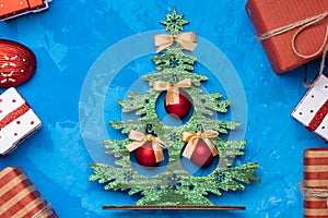 Christmas wooden tree and christrmas presents on blue cement background.Christmas decoration