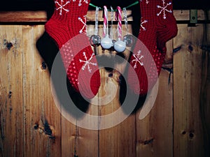 Christmas wool stockings and baubles on rustic wooden background