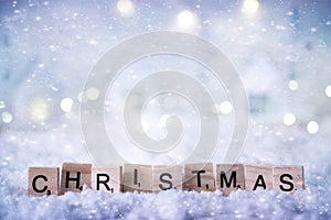 Christmas word from letters on winter background with snow and lights. Template, greeting card. Selective soft focus