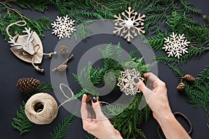 Christmas workshop of wreath, decor, twine, twigs and snowflakes. Woman prepare a wreath. Top v