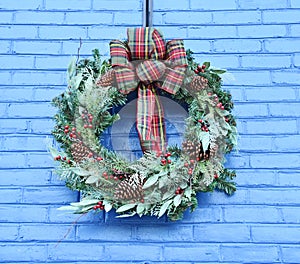 Christmas Wreath Against a Blue Brick Background