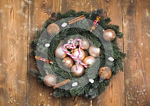Christmas wreath Beautiful wreath with cookies Cinnamone and christmas toys Candy cane Top view wooden background photo