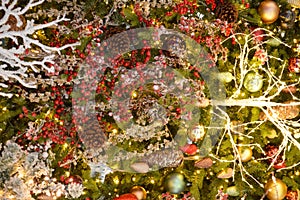 Christmas wreath of coniferous branches with cones and red berries and a garland of lights. Holiday, happy