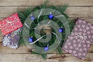 Christmas wreath with decorations and gifts on wooden background