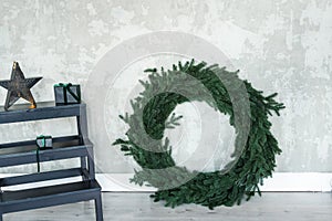 Christmas wreath without decorations leaning against the wall