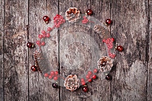 Christmas wreath of Fir branches, cones, red decorations on dark wooden background