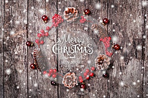 Christmas wreath of Fir branches, cones, red decorations on dark wooden background