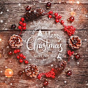 Christmas wreath of Fir branches, cones, red decorations on dark wooden background. Xmas and Happy New Year composition