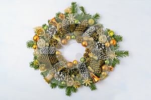 Christmas wreath with fir branches, pine cones and golden ornaments