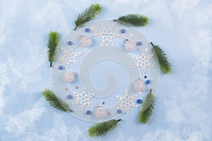 Christmas wreath with fir branches and snowflakes on pastel blue background. Ornaments with Wreath