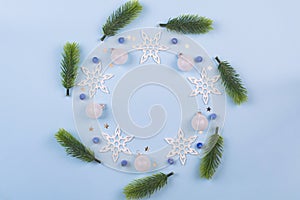 Christmas wreath with fir branches and snowflakes on pastel blue background. Ornaments with Wreath